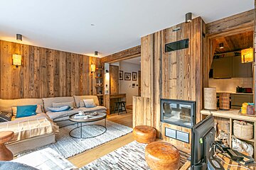 A living room with wood paneling and a fireplace