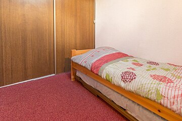 A bed with a floral comforter in a bedroom