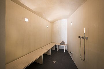 A bathroom with two benches and a shower head