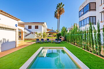 A swimming pool in the backyard of a house