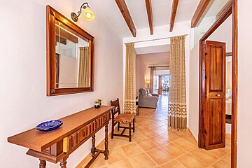 A hallway with a wooden table and a mirror