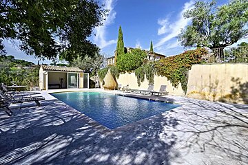 A large swimming pool with a house in the background
