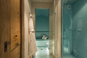 A bathroom with blue tiles and a walk in shower