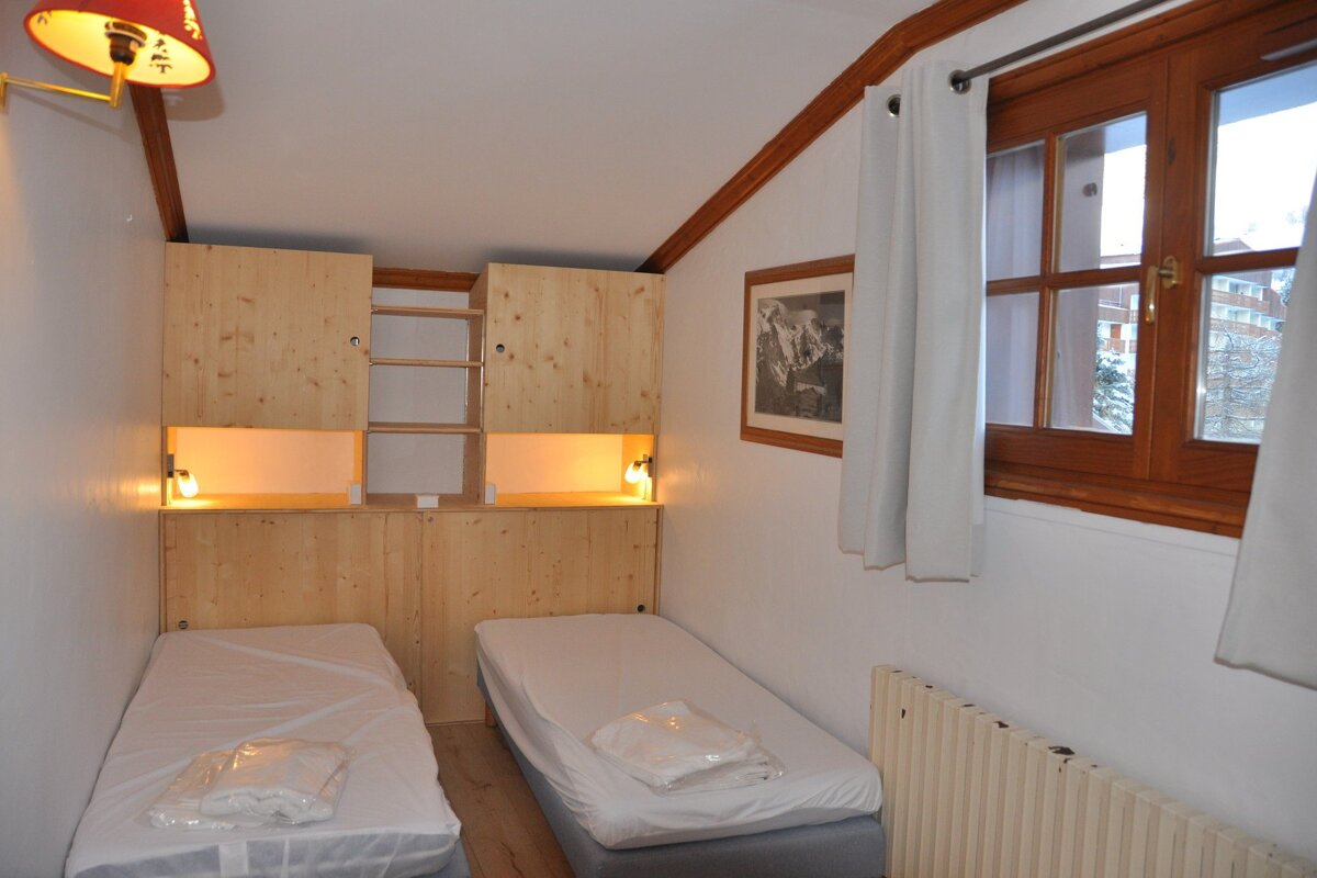 A bedroom with two beds and a picture on the wall