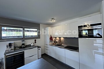 A kitchen with white cabinets and appliances and the website mobilier.com