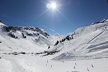 The sun is shining brightly over the snowy mountains