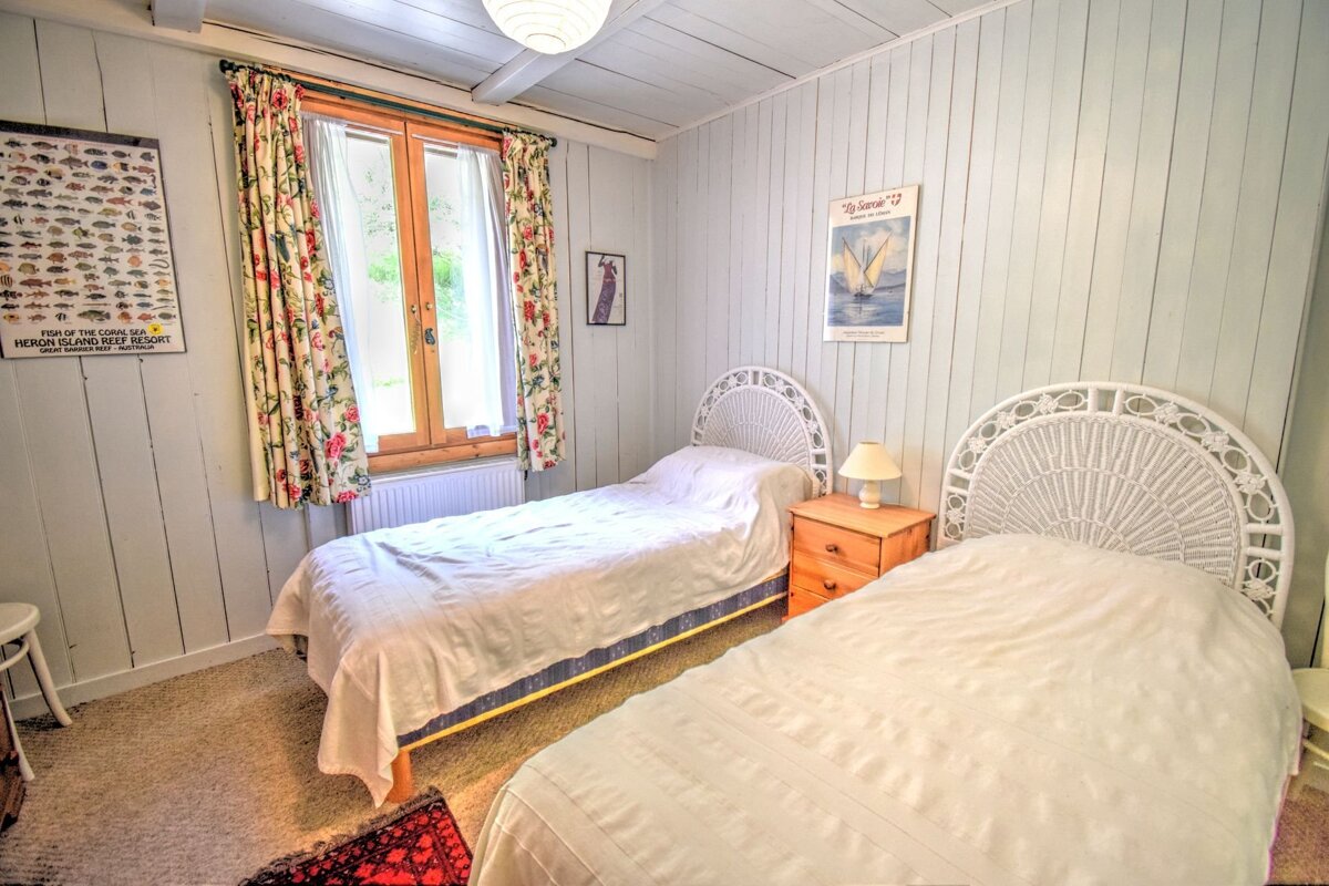 A bedroom with two beds and a poster on the wall that says french island sea resort