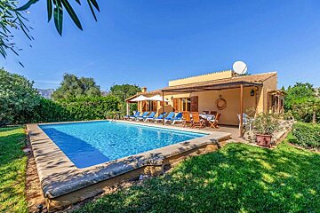 A house with a large swimming pool in front of it