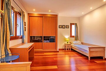 A bedroom with a single bed and a desk