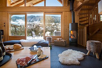 A bottle of champagne sits on a table in front of a fireplace