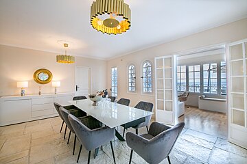 A dining room with a table and chairs and a chandelier