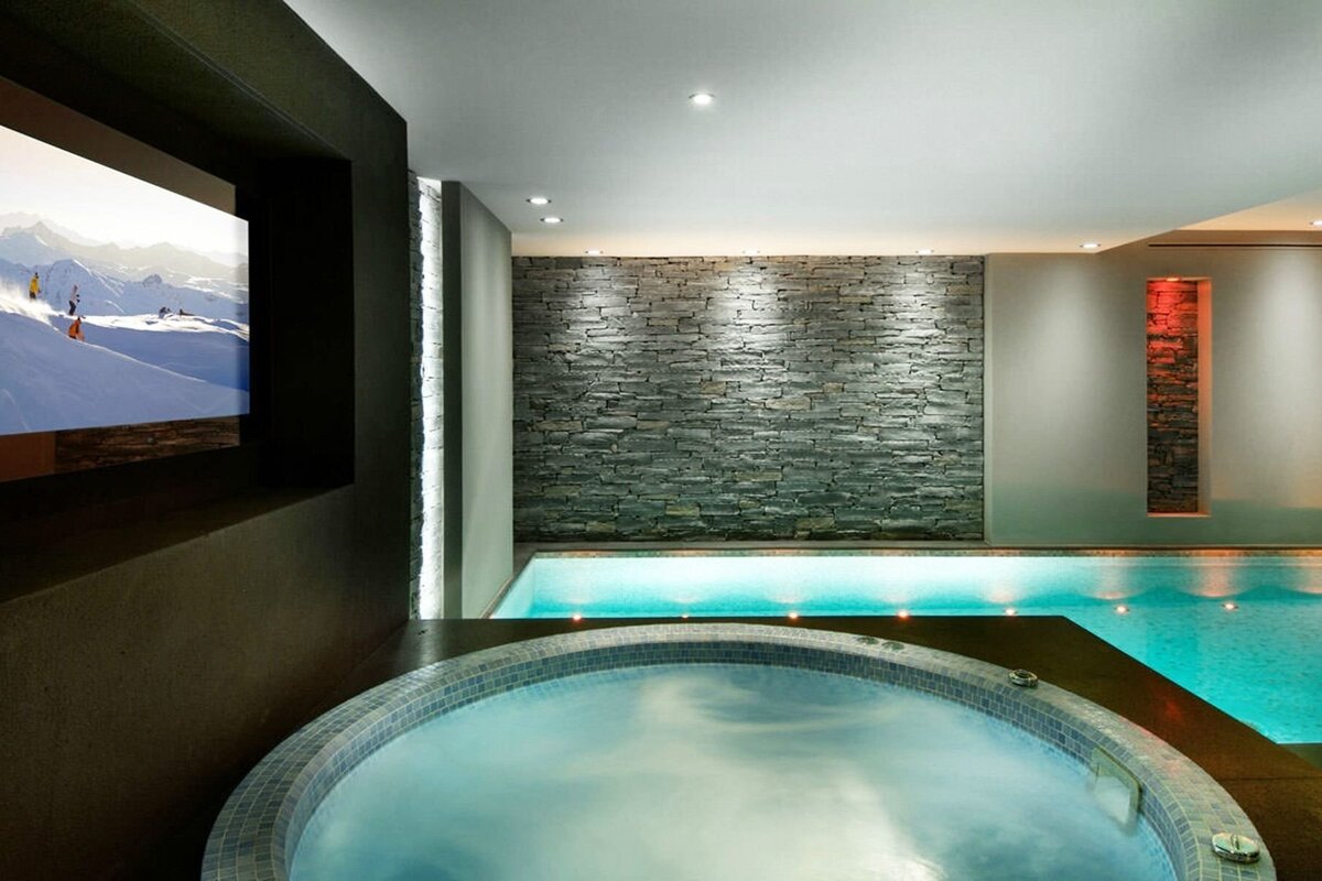 A swimming pool with a hot tub in front of it