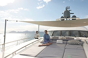 A woman sits on a couch on the deck of a boat