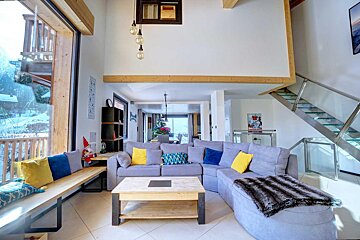A living room with a blue couch and yellow pillows