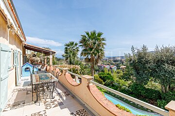 A balcony with a table and chairs overlooking a pool