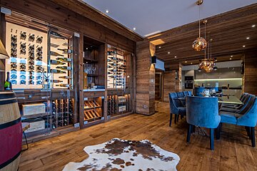 A dining room with a wine cellar and a cowhide rug