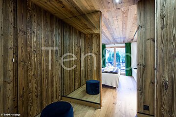 A bedroom with wooden walls and a mirror with the word ten on it