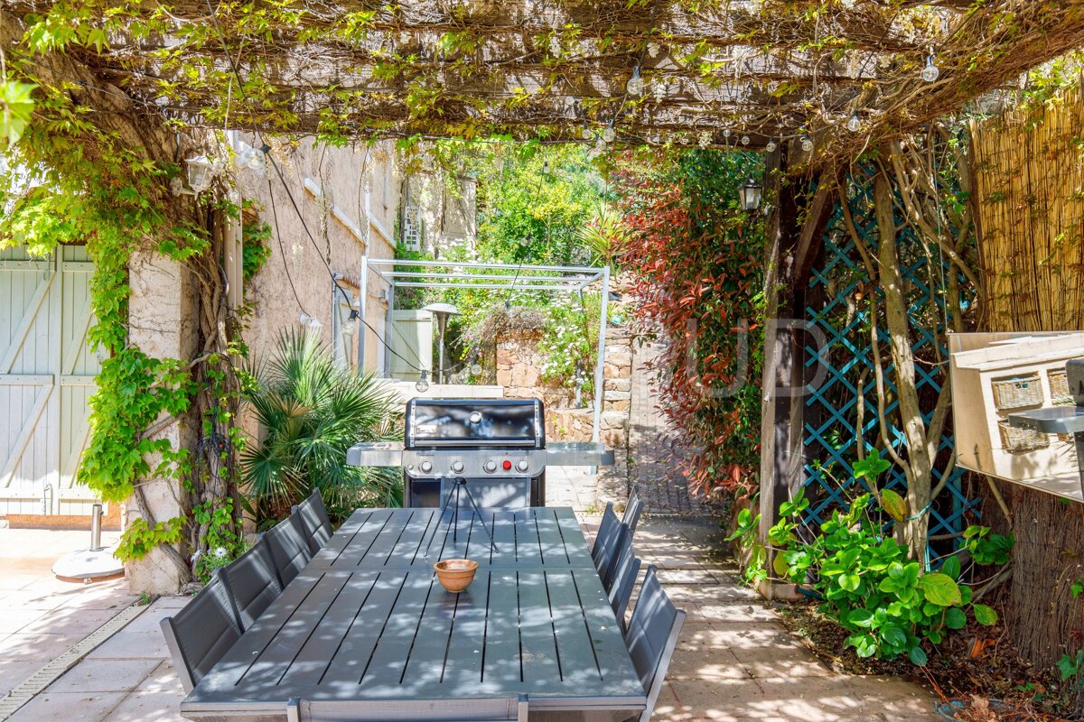 A patio area with a table and chairs under a pergola