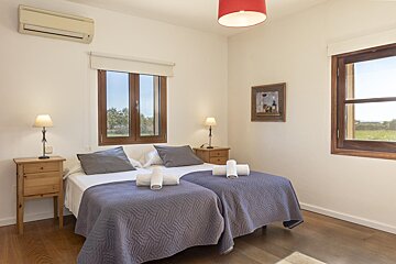 A bedroom with two beds and a picture on the wall