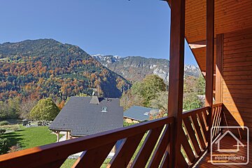 A balcony with a view of the mountains and a sign that says alpine property