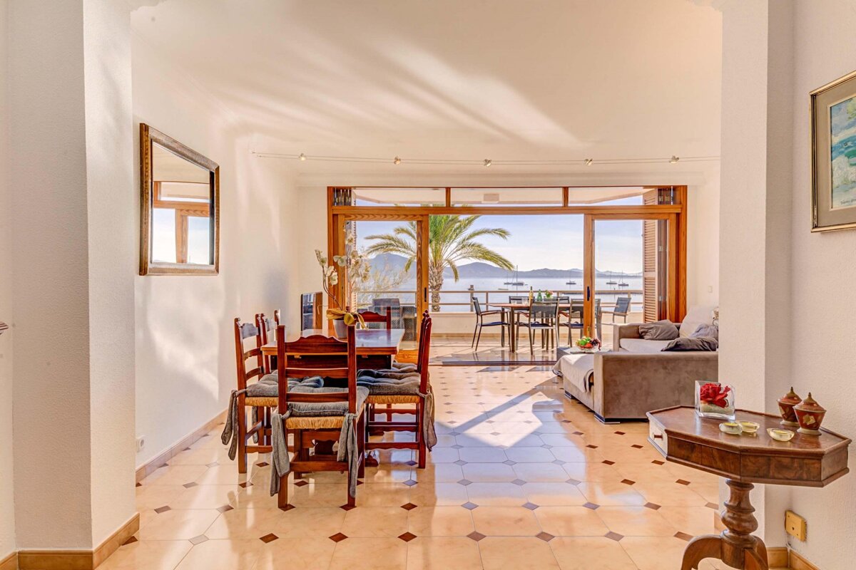 A dining room with a table and chairs and a view of the ocean