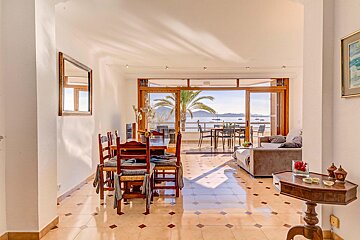 A dining room with a table and chairs and a view of the ocean