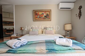 A bedroom with a bed and a painting above it that says homesud