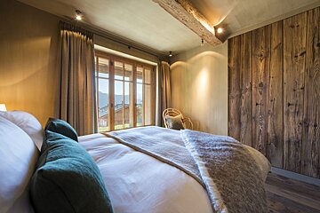 A bedroom with a large bed and a large window