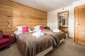 A hotel room with two beds and a chair