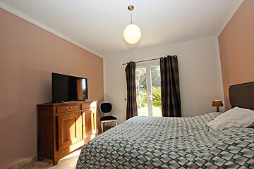 A bedroom with a large bed and a flat screen tv