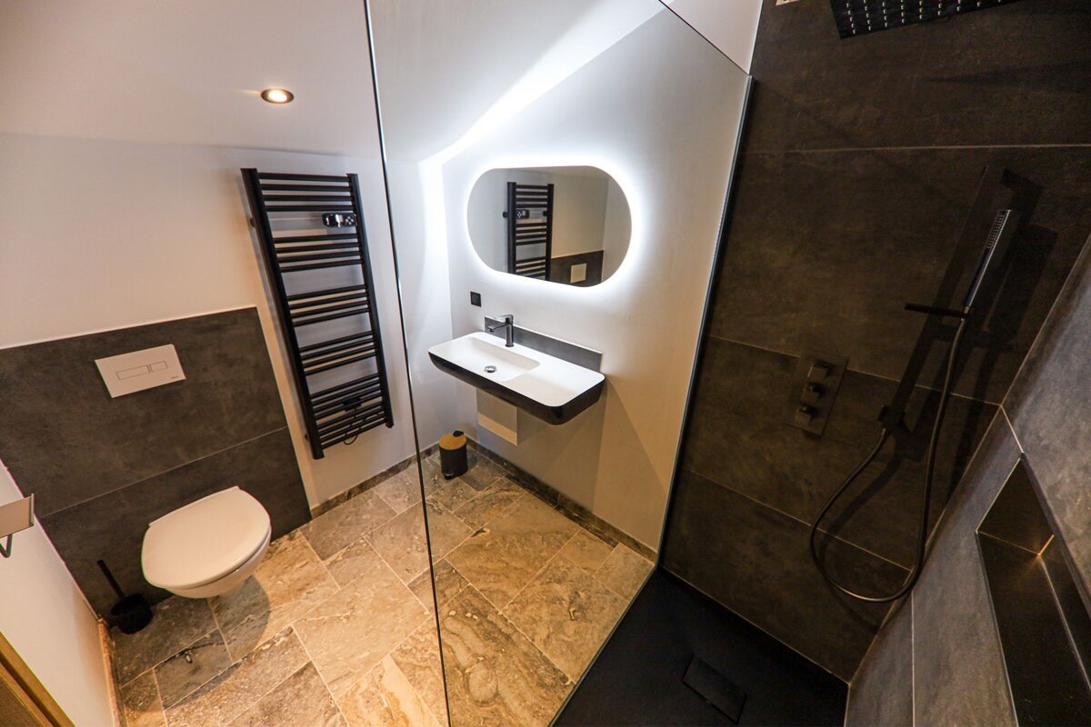 A bathroom with a toilet a sink and a mirror