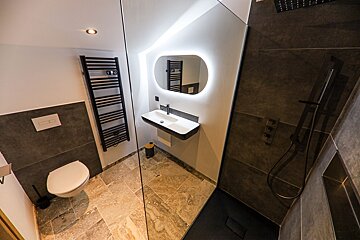 A bathroom with a toilet a sink and a mirror