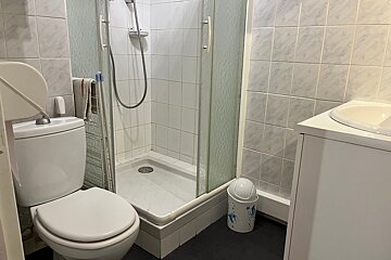 A bathroom with a toilet a sink and a shower
