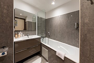 A bathroom with a bathtub and a sink with a sign that says ' toilette ' on it