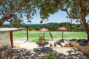 A view of a tennis court from a patio area