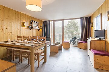 A living room with a table and chairs and a television