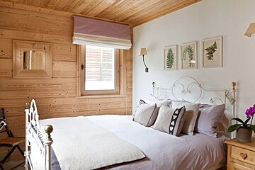 A bedroom with a bed and three pictures on the wall