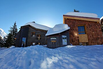 A snowy building with a sign that says ' altitude ' on it