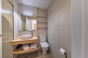 A bathroom with a toilet a sink and a mirror