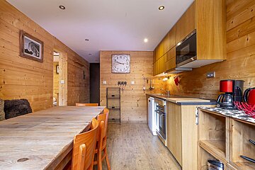 A kitchen with a clock on the wall that shows the time as 10:10