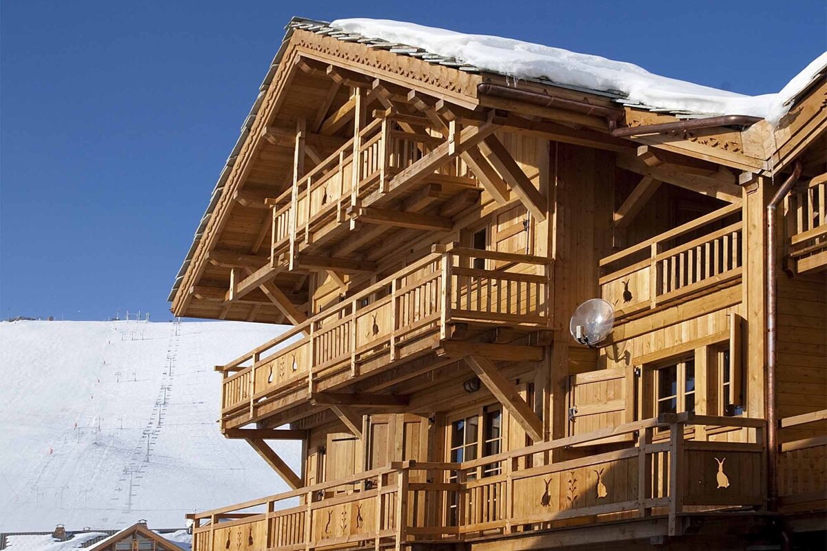 A large wooden house with a satellite dish on the side
