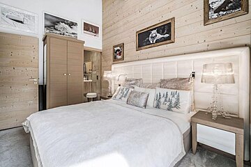 A bedroom with a large bed and pictures on the wall