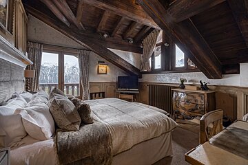 A bedroom with a large bed and a dresser