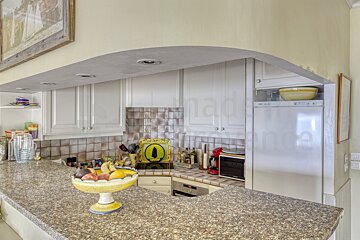 A kitchen with a fridge and a bowl of fruit on the counter