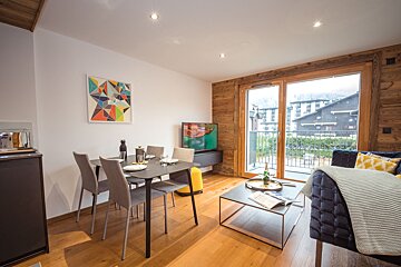 A living room with a table and chairs and a television
