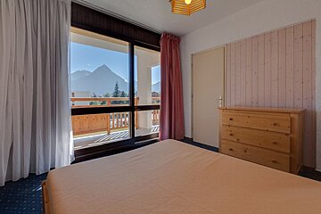 A bedroom with a sliding glass door leading to a balcony