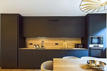 A kitchen with a table and chairs and a sign that says guichevel