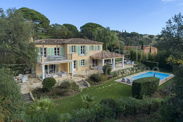 An aerial view of a large house with a large swimming pool