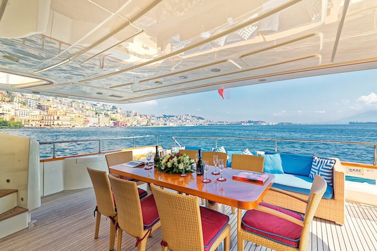 A table and chairs on the deck of a boat overlooking the ocean