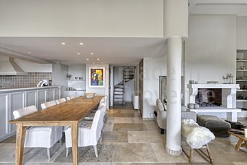 A living room with a dining table and chairs and a fireplace